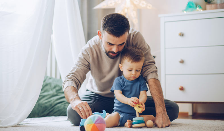 Father and son playing with stacking toys Father and son playing with stacking toys